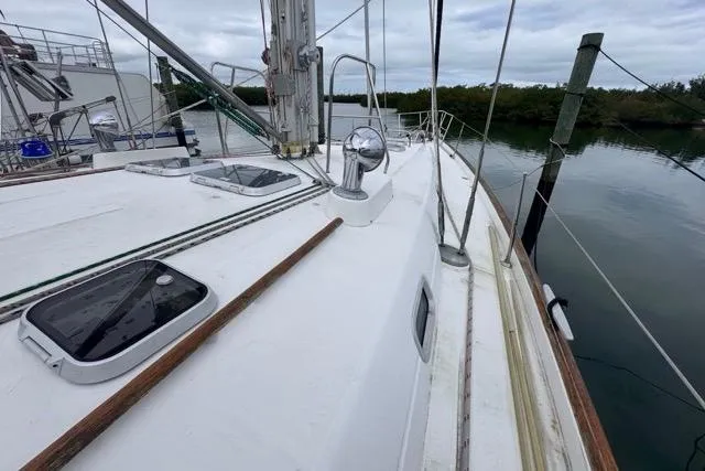 Slide: The Image of 1996 Beneteau 50 sailboat deck with hatches, docked by calm water. - 33
