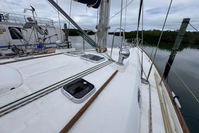 Slide: The Image of Deck view of a 1996 Beneteau 50 sailboat docked by calm waters. - 34