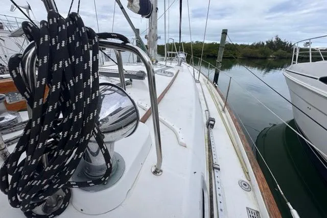 Slide: The Image of Deck view of a 1996 Beneteau 50 sailboat, featuring rigging and calm waters. - 36