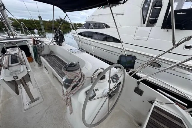 Slide: The Image of Cockpit view of a 1996 Beneteau 50 sailboat with steering wheel and seating. - 43