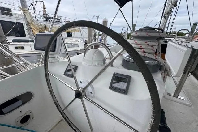 Slide: The Image of Steering wheel of a 1996 Beneteau 50 sailboat, featuring navigation instruments. - 48