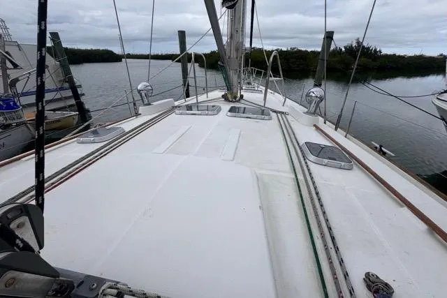 Slide: The Image of Deck view of a 1996 Beneteau 50 sailboat, moored by a calm river. - 57