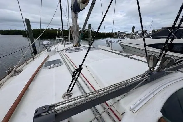 Slide: The Image of Deck view of a 1996 Beneteau 50 sailboat, featuring rigging and moored in a marina. - 58