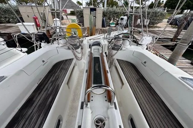 Slide: The Image of Cockpit view of a 1996 Beneteau 50 sailboat with wooden seating and steering wheel. - 59