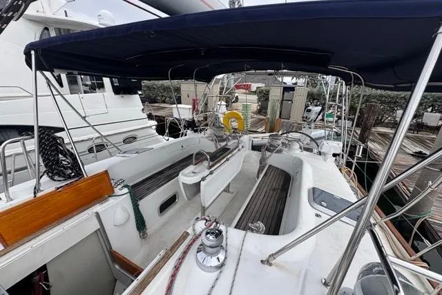Slide: The Image of Cockpit view of a 1996 Beneteau 50 sailboat with blue canopy and wooden accents. - 61