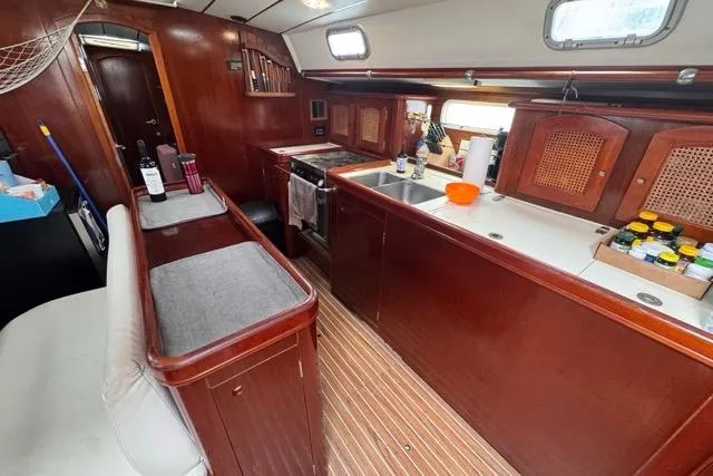 Slide: The Image of Interior of a 1996 Beneteau 50 yacht with wooden cabinetry and modern kitchen amenities. - 68