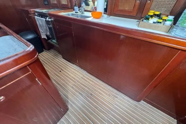 Slide: The Image of Interior of 1996 Beneteau 50 yacht with wooden cabinetry and striped flooring. - 69