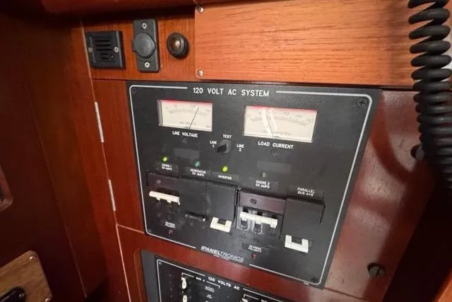 Slide: The Image of Electrical panel of a 1996 Beneteau 50 sailboat, featuring 120-volt AC system controls. - 77