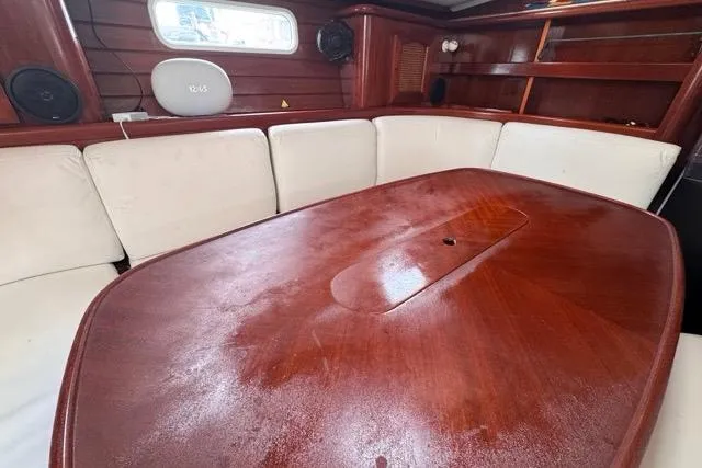 Slide: The Image of Interior of 1996 Beneteau 50 yacht with wooden table and white seating. - 80