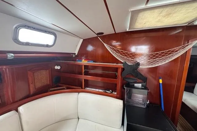 Slide: The Image of Interior of 1996 Beneteau 50 yacht with wooden finish and white seating. - 81