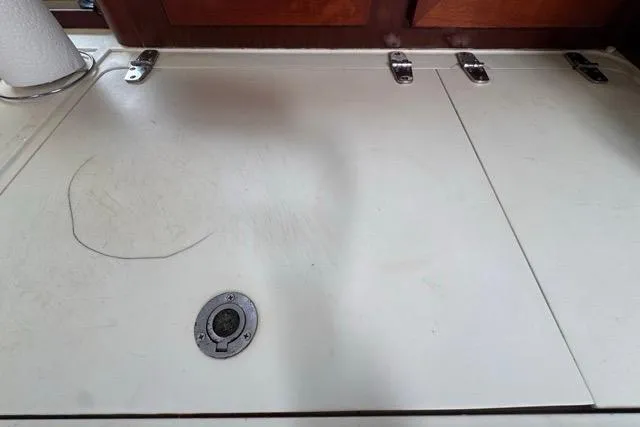 Slide: The Image of Interior view of a 1996 Beneteau 50 yacht, featuring a white countertop with metal hinges. - 82