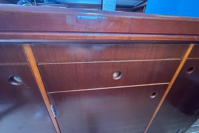 Slide: The Image of Wooden cabinetry inside a 1996 Beneteau 50 sailboat, featuring drawers and storage compartments. - 83