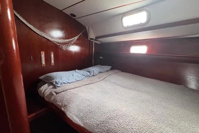 Slide: The Image of Cozy cabin interior of 1996 Beneteau 50 sailboat with wooden finish and bed. - 87