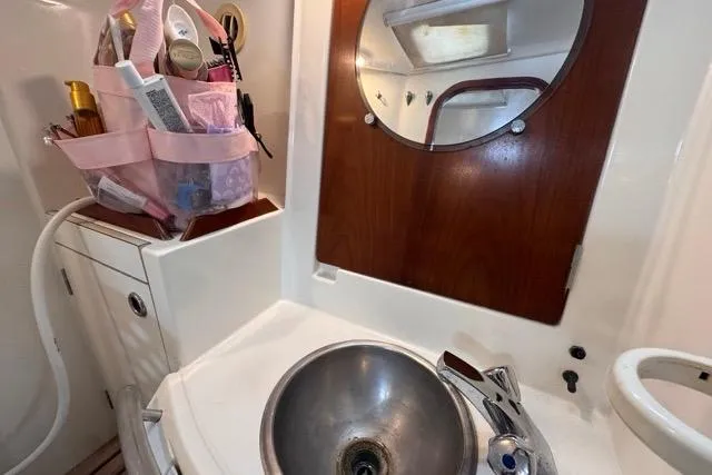 Slide: The Image of Bathroom sink area in a 1996 Beneteau 50 yacht with toiletries and mirror. - 91