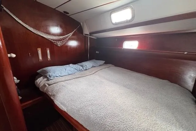 Slide: The Image of Cozy cabin interior of 1996 Beneteau 50 sailboat with wooden finish and comfortable bedding. - 93