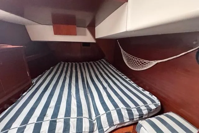 Slide: The Image of Cozy cabin interior of 1996 Beneteau 50 sailboat with striped bedding. - 98