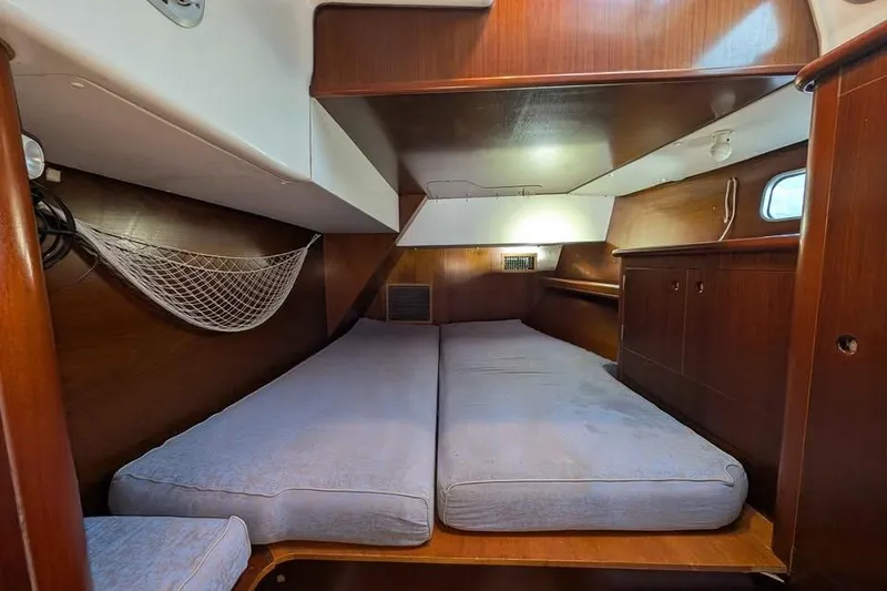 Slide: The Image of Cozy cabin interior of a 1996 Beneteau 50 sailboat with wooden finish and twin beds. - 99