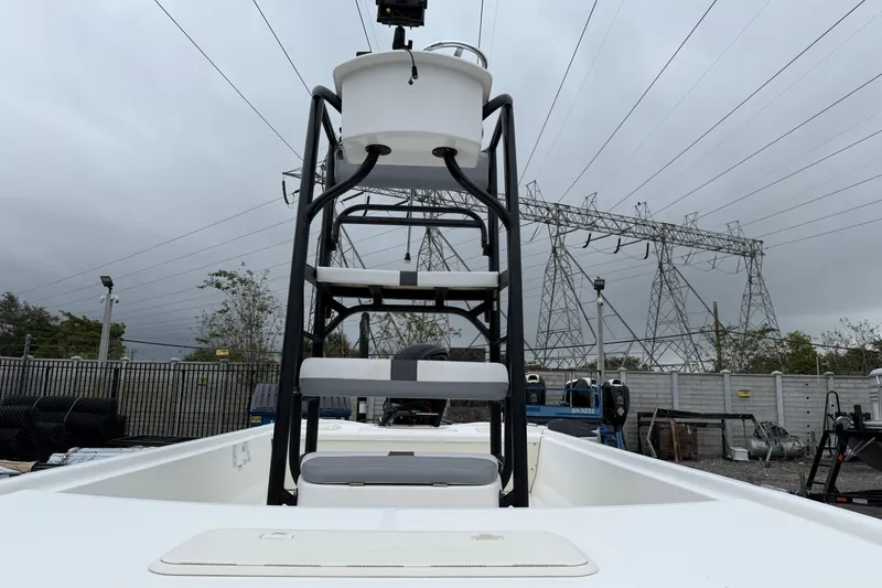 Slide: The Image of 2018 Mako Pro Skiff 19 CC Top Drive boat with elevated seating, parked outdoors. - 7