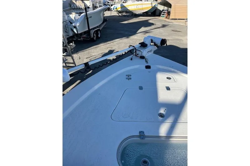 Slide: The Image of 2023 Sea Pro 248 Bay boat deck with trolling motor in a marina setting. - 5