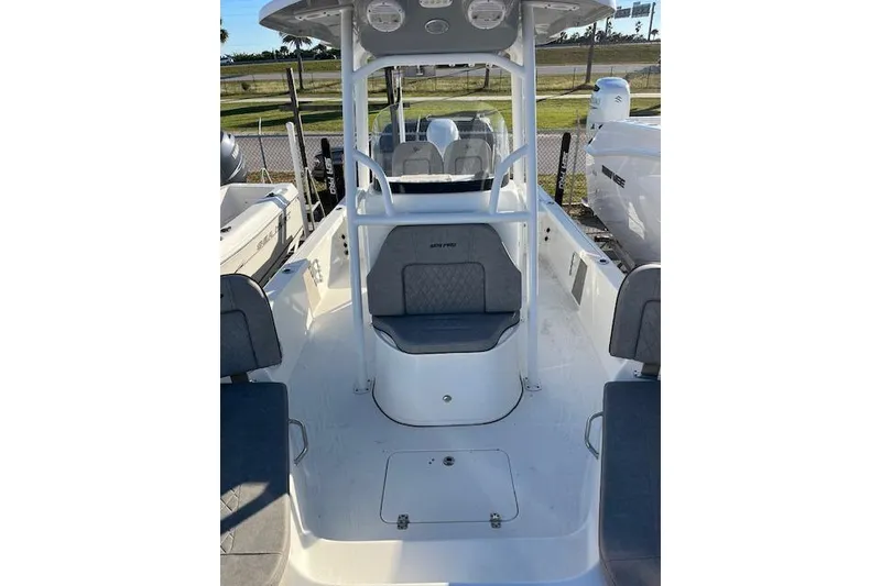 Slide: The Image of 2023 Sea Pro 248 Bay boat interior with seating and console, docked outdoors. - 7