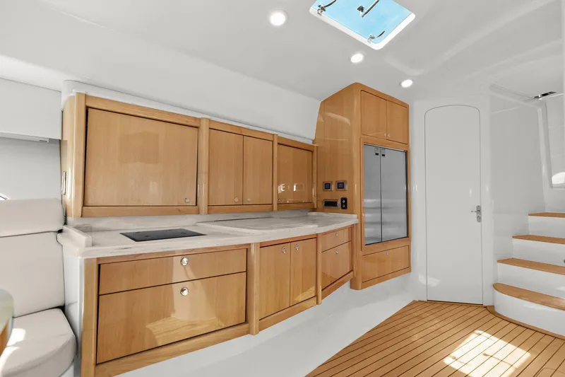 Slide: The Image of Interior view of 2019 Intrepid 475 yacht with ocean visible through sleek windows. - 21