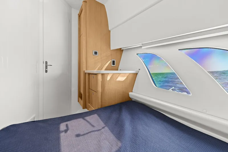 Slide: The Image of 2019 Intrepid 475 cabin interior with cozy bed and striped pillows. - 27