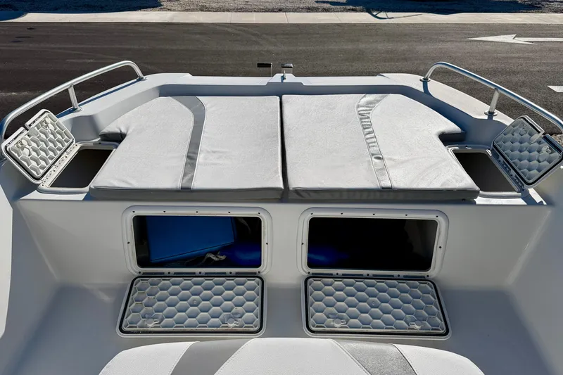 Slide: The Image of 2011 Carolina Cat 18 CC boat with open storage compartments and cushioned seating. - 11