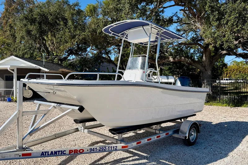 Slide: The Image of 2011 Carolina Cat 18 CC boat on trailer, parked outdoors under trees. - 2