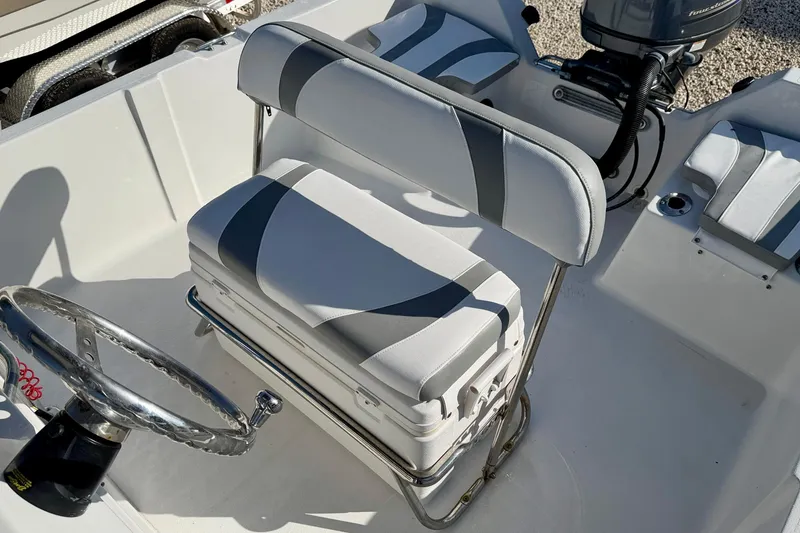 Slide: The Image of 2011 Carolina Cat 18 CC boat interior with steering wheel and cushioned seating. - 21