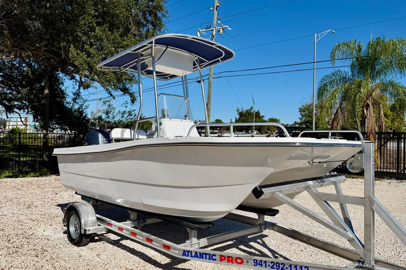 Slide: The Image of 2011 Carolina Cat 18 CC boat on trailer, parked outdoors under clear blue sky. - 4