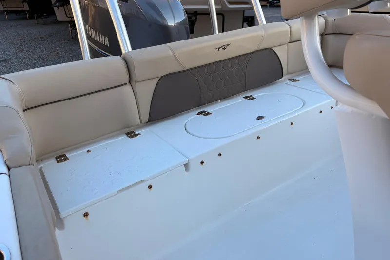 Slide: The Image of 2018 Tidewater 210 LXF boat interior with cushioned seating and storage compartments. - 10