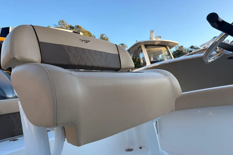 Slide: The Image of 2018 Tidewater 210 LXF boat seat with beige upholstery and steering wheel. - 11