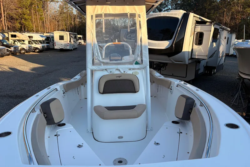 Slide: The Image of 2018 Tidewater 210 LXF boat with seating, parked near RVs and trees. - 8