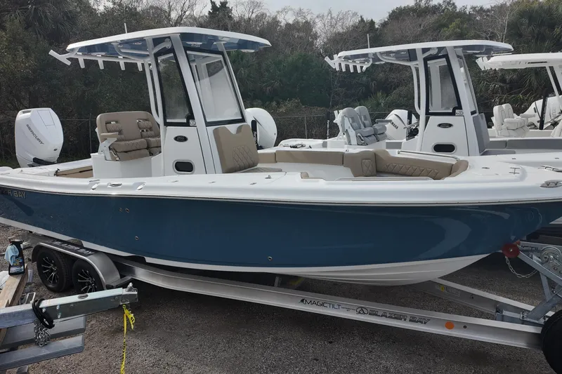 The Image of 2026 Blazer 2600 Makaira boat on trailer, blue hull, parked outdoors. - 0