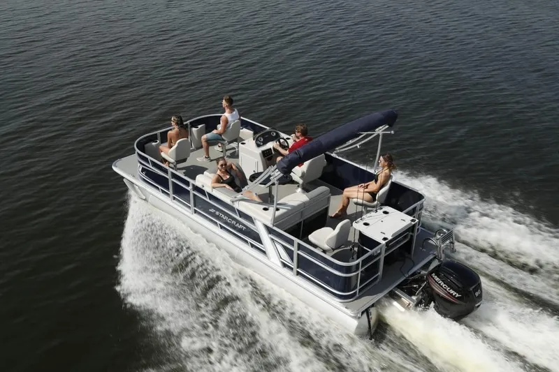 Slide: The Image of 2025 Starcraft 22 LX pontoon boat cruising on water with passengers enjoying the ride. - 10