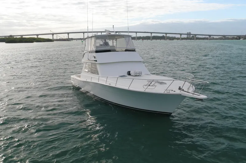 Slide: The Image of 1996 Viking 50 Sport Fisher Convertible yacht on open water near a bridge. - 31