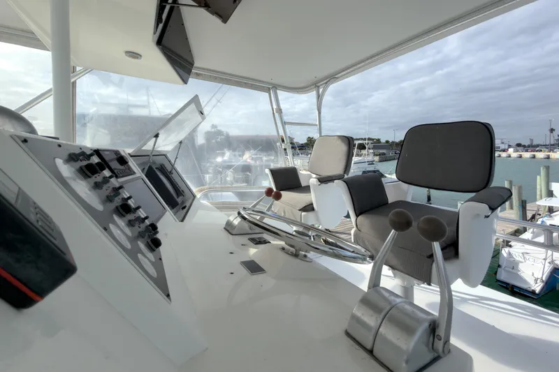 Slide: The Image of 1996 Viking 50 Sport Fisher Convertible helm with controls and seating, docked at marina. - 33