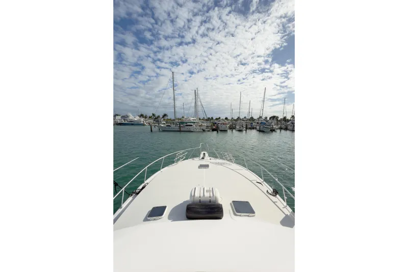 Slide: The Image of Bow view of 1996 Viking 50 Sport Fisher Convertible at marina under cloudy sky. - 49