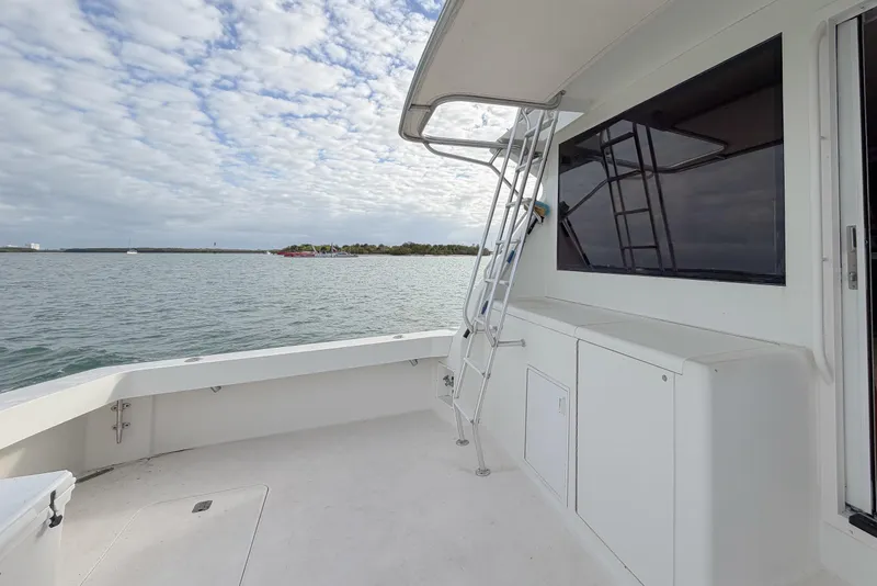 Slide: The Image of 1996 Viking 50 Sport Fisher Convertible boat deck with ocean view and ladder. - 52