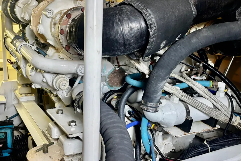 Slide: The Image of Engine room of a 1996 Viking 50 Sport Fisher Convertible with visible hoses and components. - 62