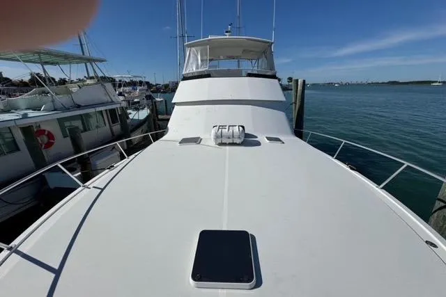 Slide: The Image of 1996 Viking 50 Sport Fisher Convertible cruising on open water near a bridge. - 9