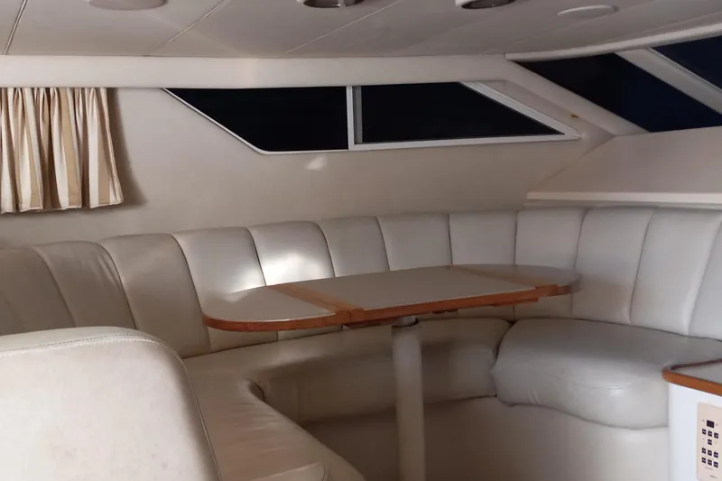 Slide: The Image of Interior of 1997 Sea Ray 440 Express yacht with white leather seating and table. - 10