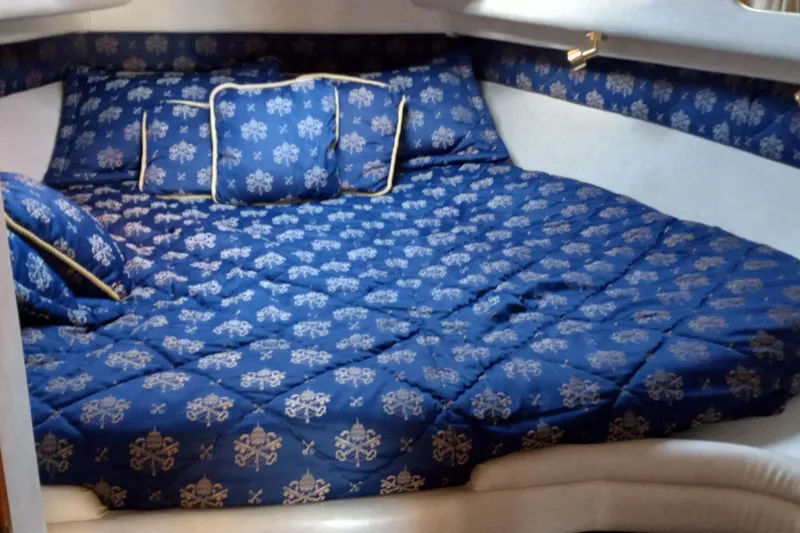 Slide: The Image of Luxurious cabin interior of 1997 Sea Ray 440 Express with blue patterned bedding. - 11