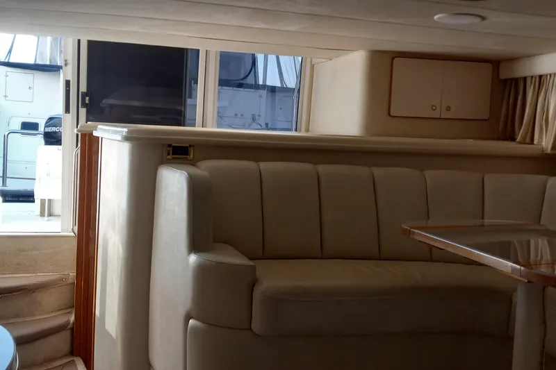 Slide: The Image of Interior of 1997 Sea Ray 440 Express yacht with beige seating and table. - 14
