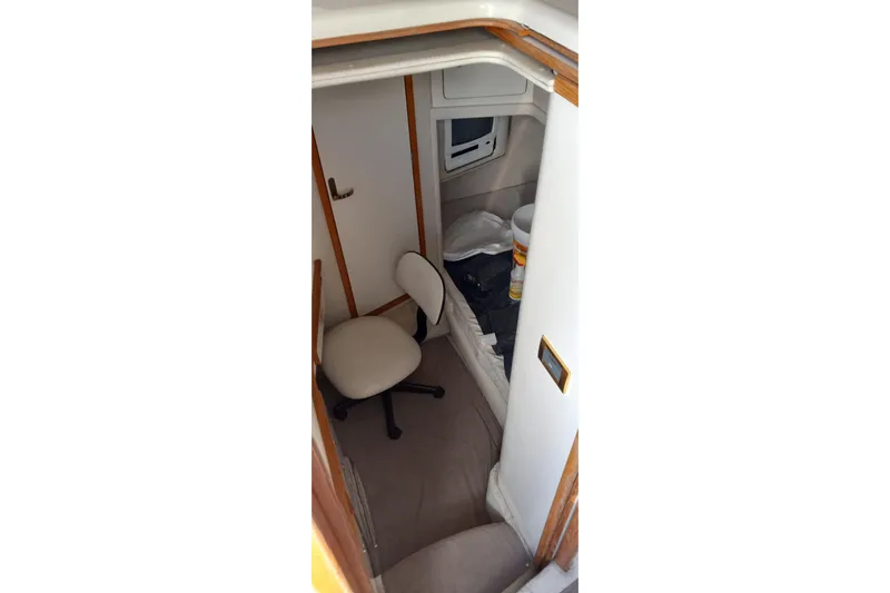 Slide: The Image of Interior cabin of 1997 Sea Ray 440 Express with chair and storage space. - 15