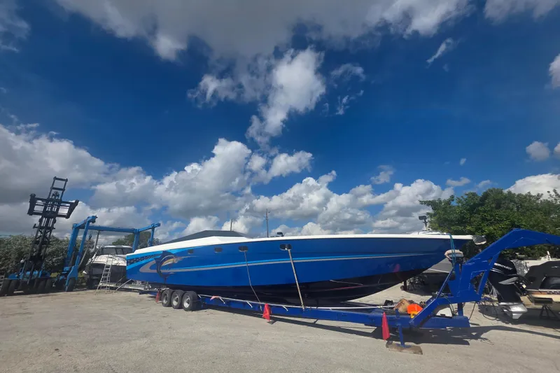 Slide: The Image of Blue 2025 Don Smith Custom 55' boat on trailer under a vibrant sky. - 1