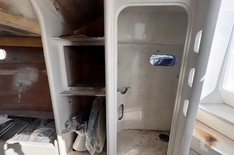 Slide: The Image of Interior of 2025 Don Smith Custom 55' boat, featuring storage shelves and small window. - 13