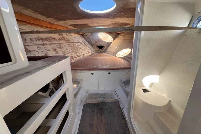 Slide: The Image of Interior of 2025 Don Smith Custom 55' boat, featuring unfinished cabin space with circular windows. - 20