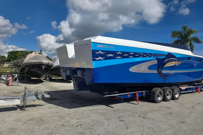 Slide: The Image of 2025 Don Smith Custom 55' boat on trailer, vibrant blue design with marlin graphic. - 3