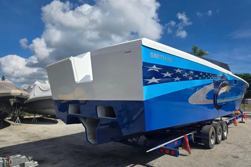 Slide: The Image of 2025 Don Smith Custom 55' boat with vibrant blue design on trailer. - 4